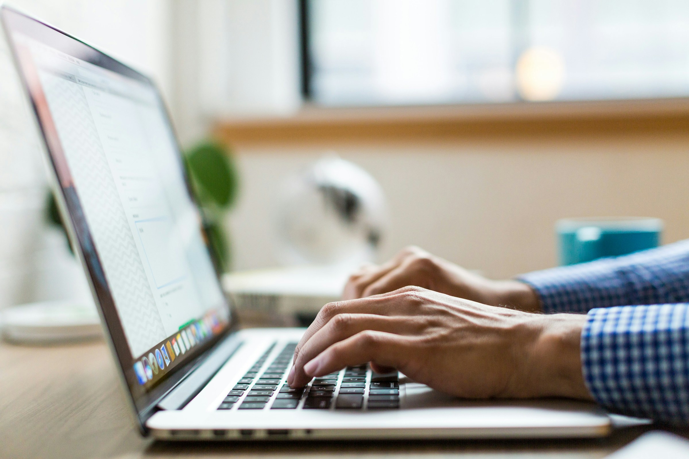 Man typing on a laptop. 