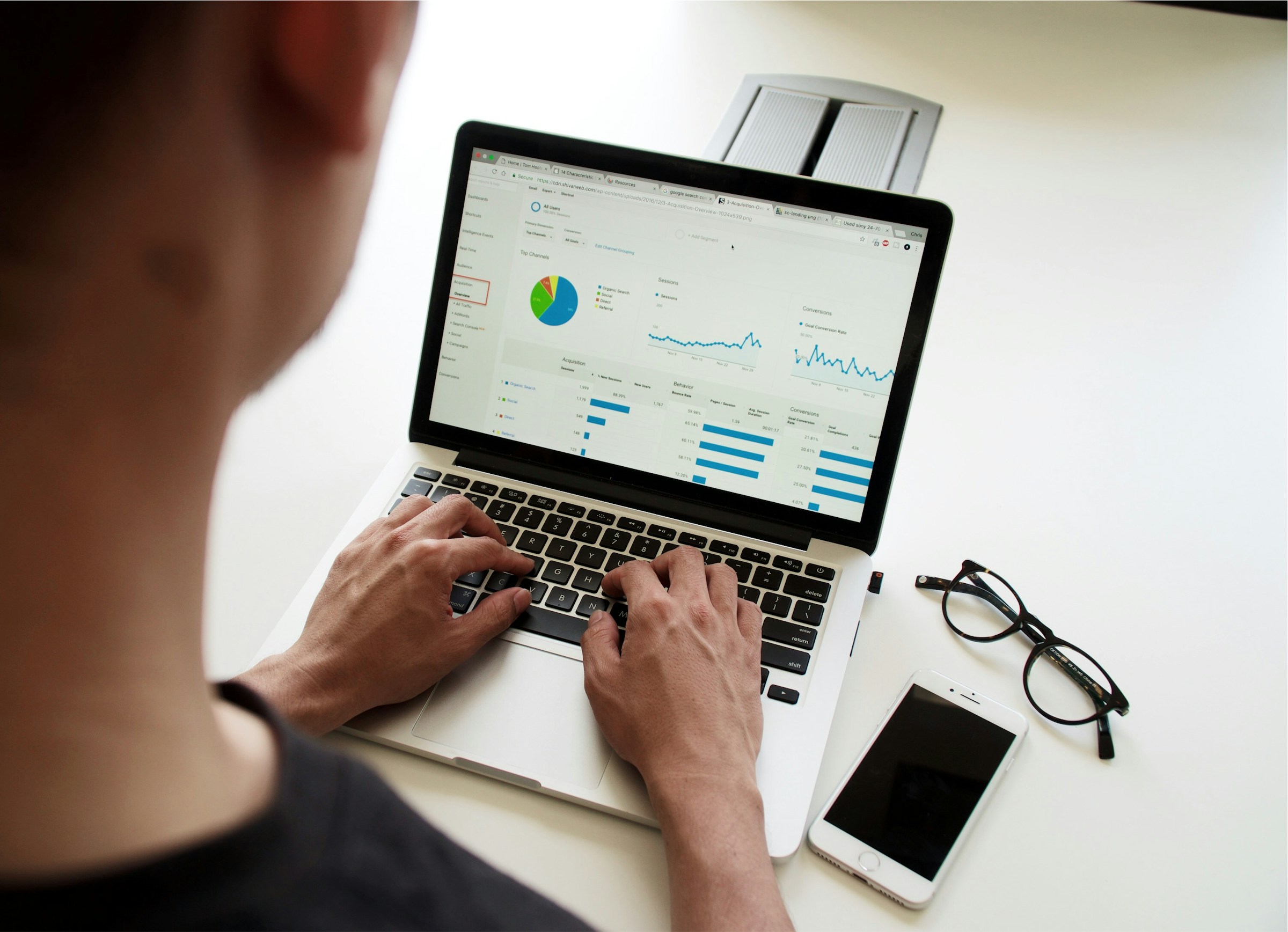 A man looking at Google Analytics on a laptop. 