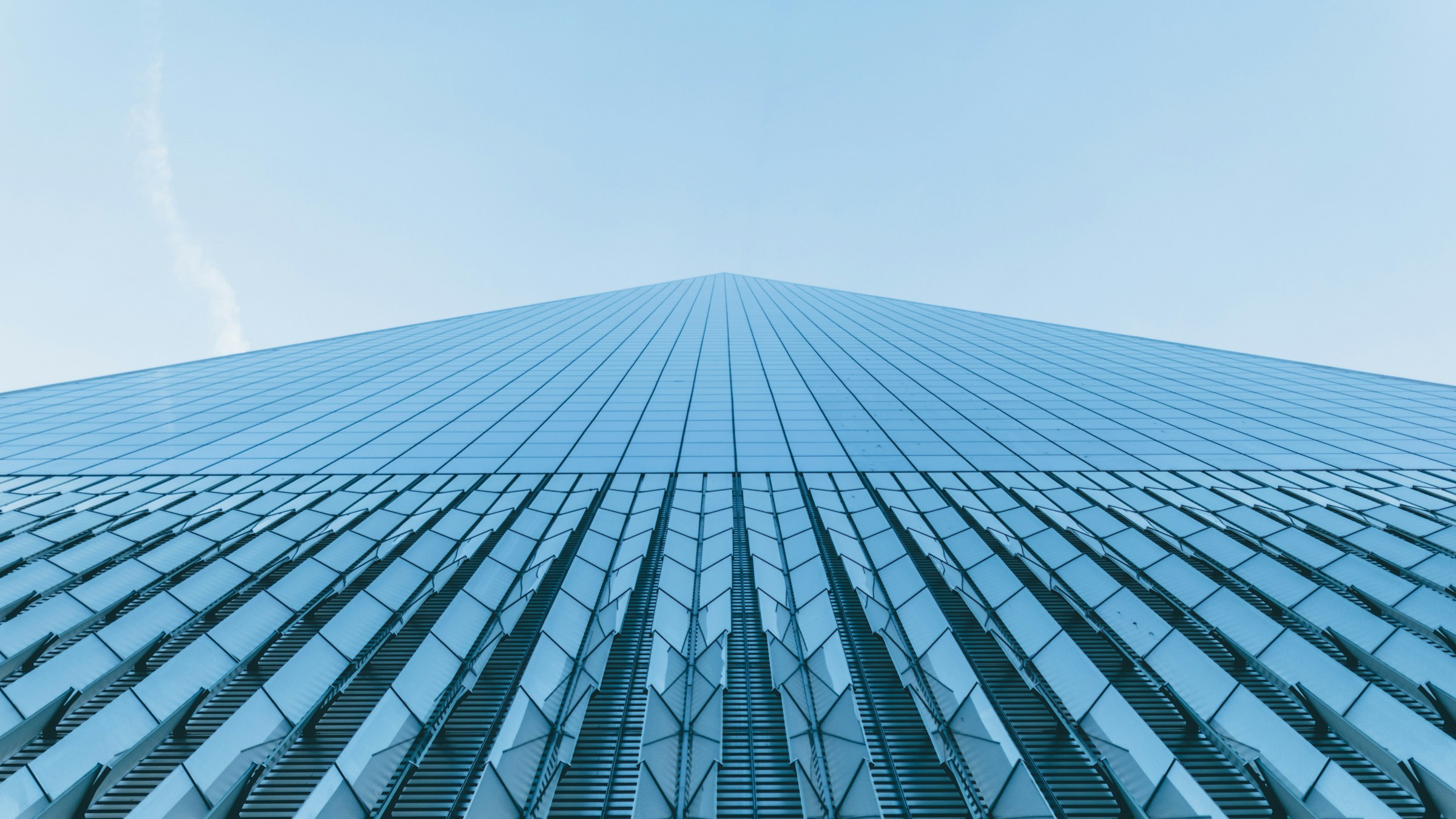 looking up the side of a skyscraper into clear blue sky