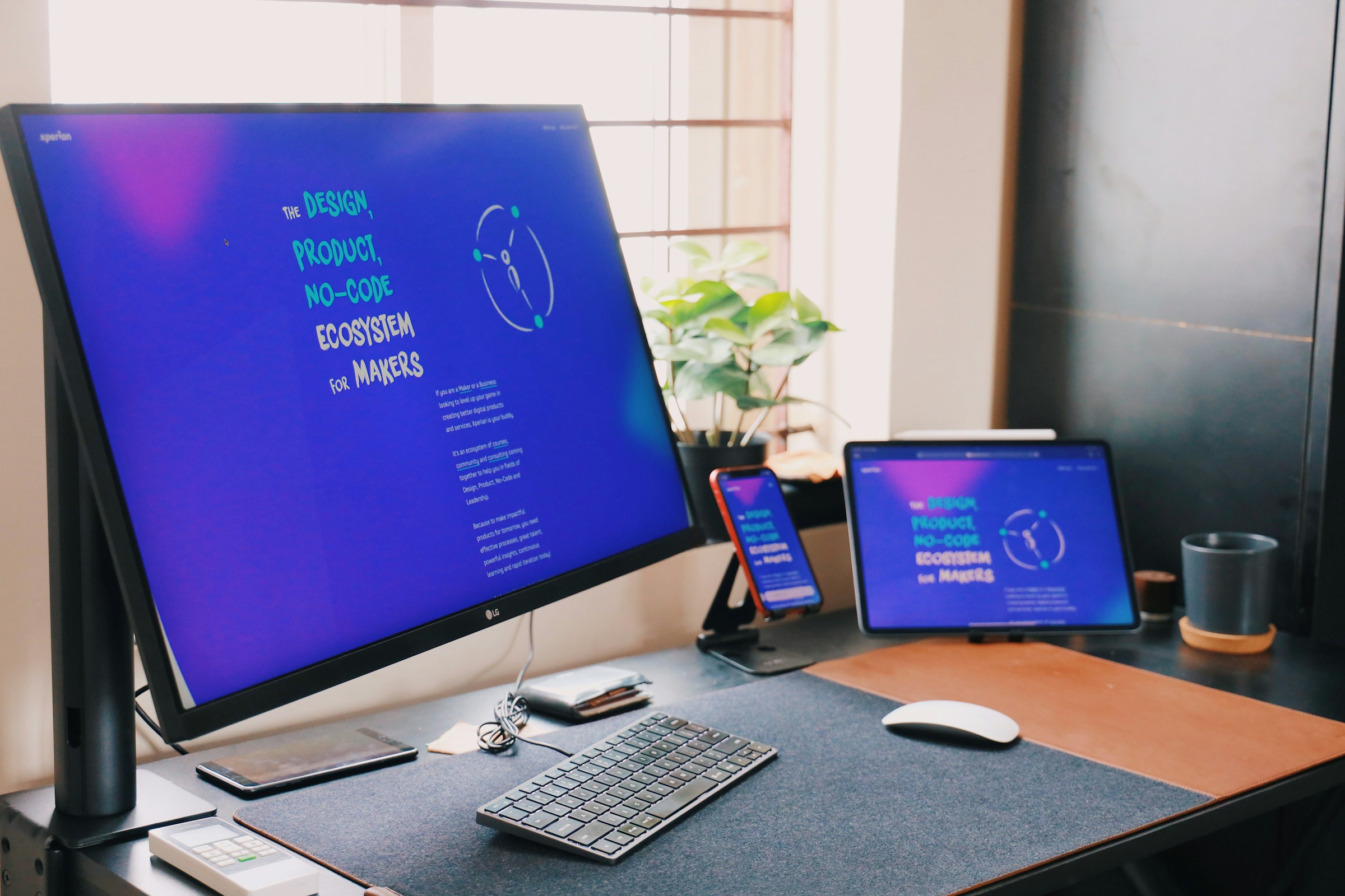 A workspace with the same website displayed on three different sized screens. 